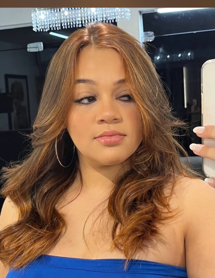 Cliente com cabelos iluminados por mechas no ambiente sofisticado do Studio Iara David em Ribeirão Preto